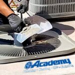 Academy Plumbing technician repairing an air conditioner condenser fan in Albuquerque